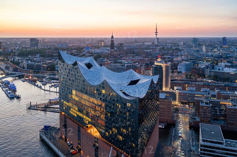 Aerial view of the Elbphilharmonie at sunset with illuminated windows and view over Hamburg, Landungsbrücken and the main church St. Michaelis (Michel), Hamburg, Germany, Europe