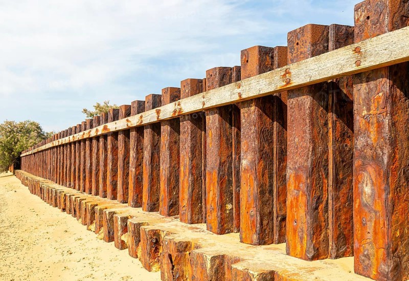 Old rusty steel sheet piling sea wall coastal defence, River Deben, Bawdsey, Suffolk, England, UK