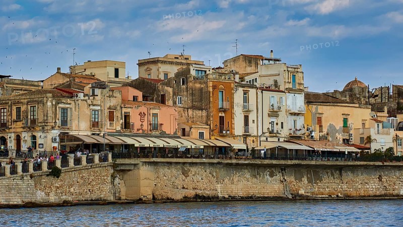 Coastal view with a mix of old buildings and modern terraces along the waterfront, boat trip around the island of Ortigia, Isola di Ortigia, Syracuse, Sicily, Italy, Europe