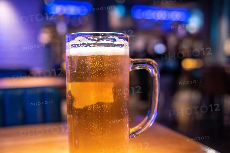 Cold beer waiting on the table in a lively london pub, inviting friends to enjoy a refreshing drink in a vibrant evening atmosphere