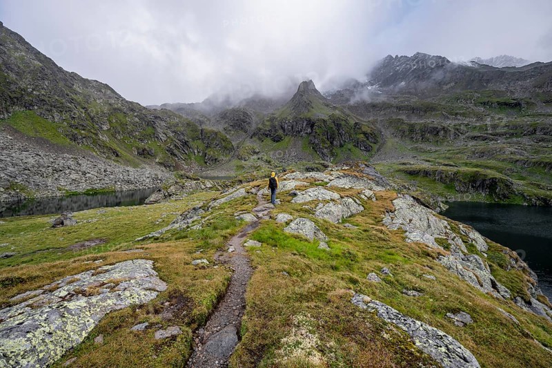 Mountaineers on a hiking trail between the mountain lakes Wangenitzsee and Kreuzsee, cloudy mountain peaks, Schober Group, Hohe Tauern National Park, Carinthia, Austria, Europe