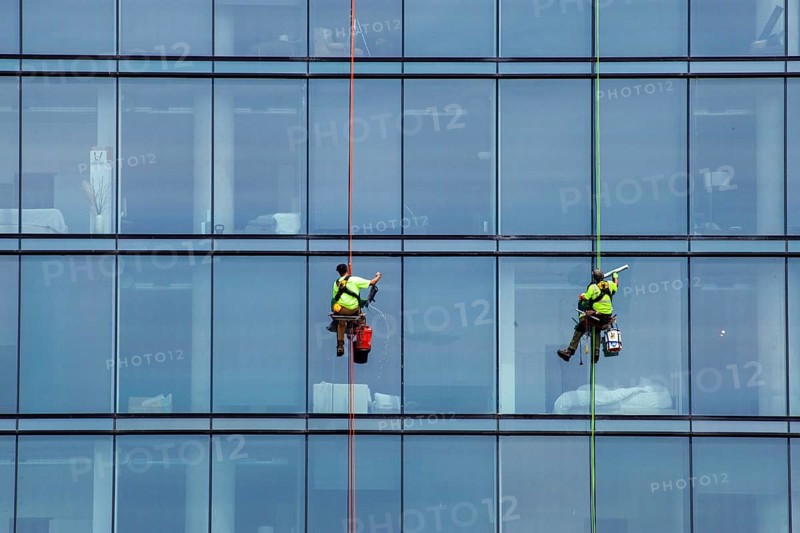 Detroit, Michigan - Window washers at the 25-story Residences Water Square luxury apartment building