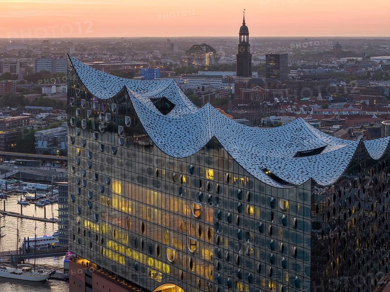 Aerial view of the Elbphilharmonie at sunset with illuminated windows and view over Hamburg and the main church St Michaelis (Michel), Hamburg, Germany, Europe