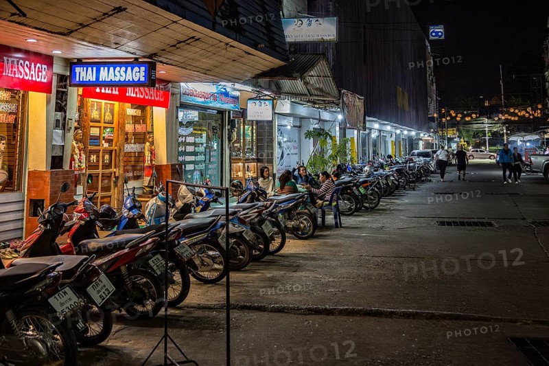 Massage parlor employees waiting for customers along a street in Chiang Rai, Thailand, Asia
