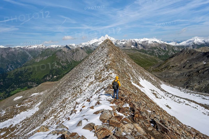 Mountaineer climbing to the summit of Böses Weibl, view of mountain landscape with snow-covered summit of the Großglockner, Wiener Höhenweg, Schober group, Hohe Tauern National Park, Carinthia, Austria, Europe