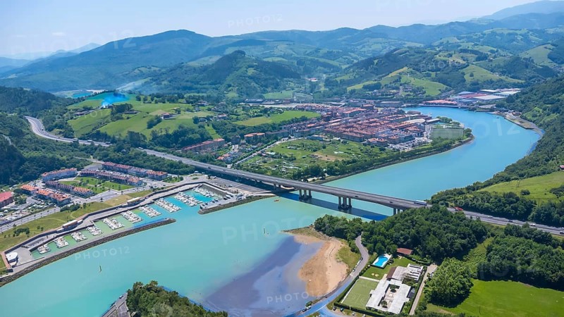 Aerial view of orio, a charming town in gipuzkoa, basque country, spain, showcasing the river, bridge, marina, and surrounding landscape on a sunny summer day