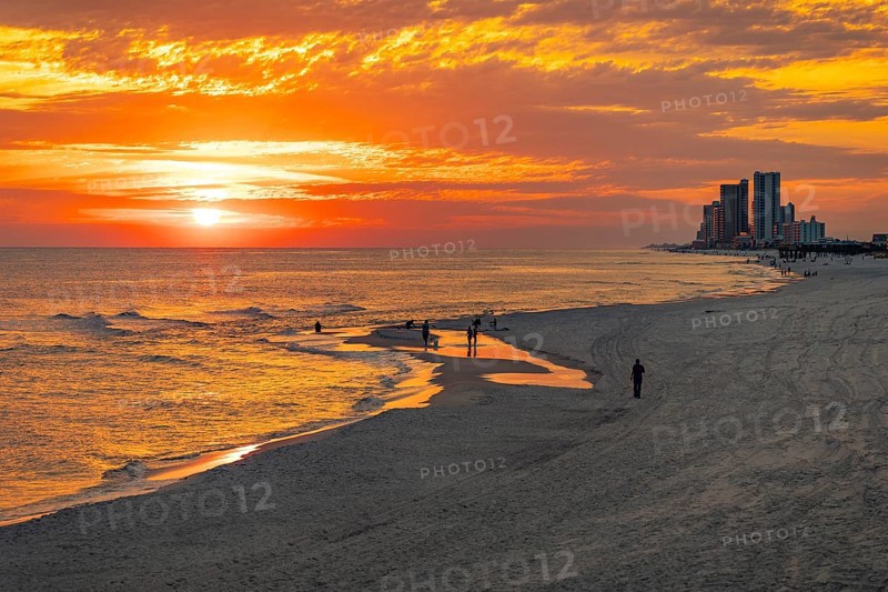 People playing and fishing on the beach at sunset on the Gulf of Mexico at Gulf Shores, Alabama