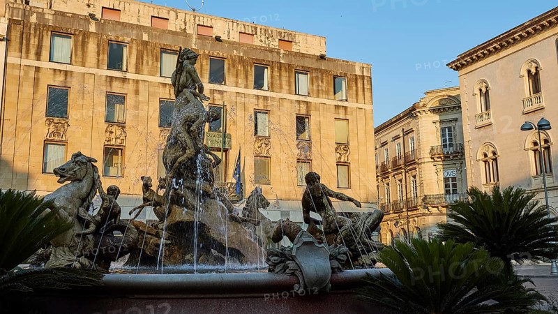 Piazza Archimede, Fontana di Diana, Diana Fountain, Baroque fountain with sculptures of horses and figures in front of old buildings under a blue sky, Ortigia Island, Isola di Ortigia, Historic Old Town, Syracuse, Sicily, Italy, Europe