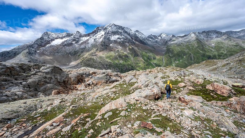 Mountaineer on hiking trail, rocky mountain landscape, behind mountain peak Roter Knopf with fresh snow in summer, descent from the Hornscharte on the Wiener Höhenweg, Schober group, Hohe Tauern National Park, Carinthia, Austria, Europe