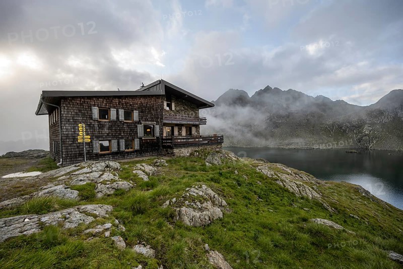 Mountain hut Wangenitzseehütte, cloudy mountain landscape with mountain lake Wangenitzsee, Wiener Höhenweg, Schober group, Hohe Tauern National Park, Carinthia, Austria, Europe