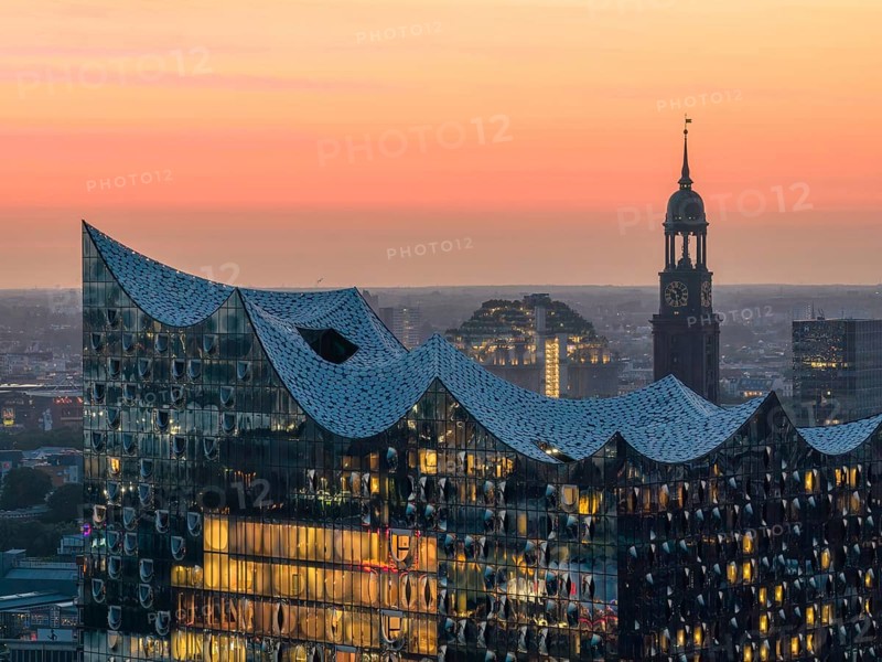 Aerial view of the Elbphilharmonie at sunset with illuminated windows and view over Hamburg and the main church St Michaelis (Michel), Hamburg, Germany, Europe