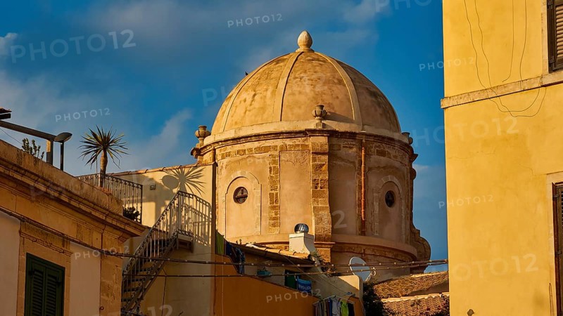 Historic dome in an old town setting with yellow buildings and palm trees, blue sky, Ortigia Island, Isola di Ortigia, Historic old town, Syracuse, Sicily, Italy, Europe