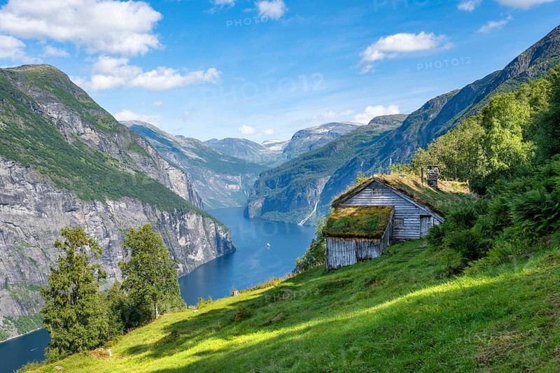 Blomberg Gård, historic mountain farm with grass roof on a steep mountainside above the Geirangerfjord, view of idyllic fjord landscape, near Geiranger, Møre og Romsdal, Norway, Europe