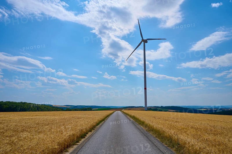 Rural landscape with wind turbine and cornfield and road under blue sky, summer, Retzstadt, Main Spessart district, Bavaria, Germany, Europe