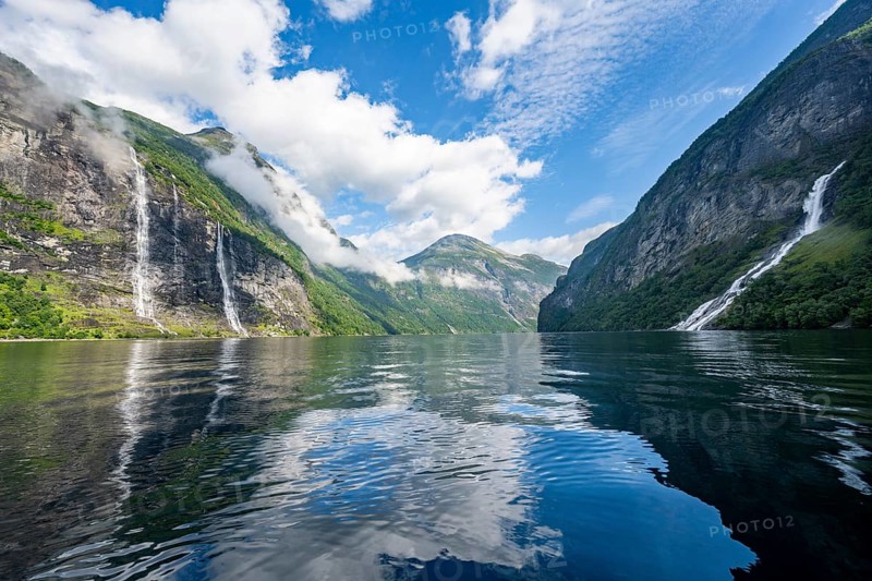Atmospheric fjord landscape with waterfall The Seven Sisters and Freier Waterfall, Geirangerfjord with reflection, Møre og Romsdal, Norway, Europe