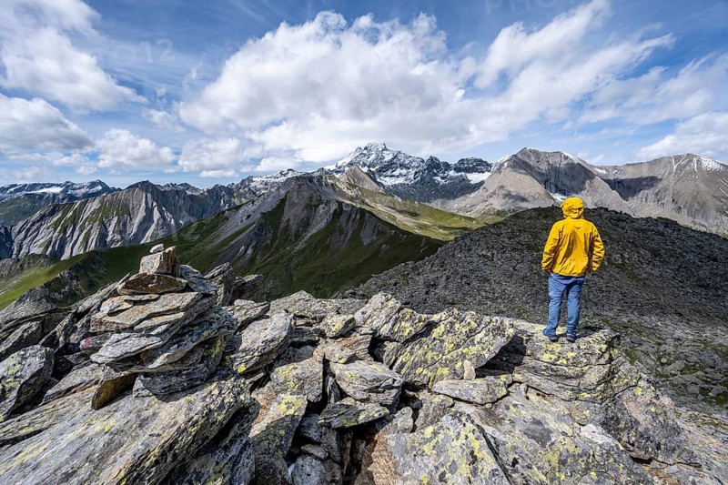 Mountaineer on the summit of Kastenegg, view of picturesque mountain landscape with snow-covered summit of the Großglockner, Vienna High Mountain Trail, Schober Group, Hohe Tauern National Park, Carinthia, Austria, Europe