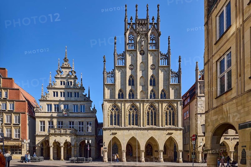 Historic town hall, facade, windows, arcades, gable, cobblestone street, pedestrians as secondary motif, blue cloudless sky, intersection Prinzipalmarkt with Michaelisplatz, Münster, Münsterland, independent city, North Rhine-Westphalia, Germany, Europe