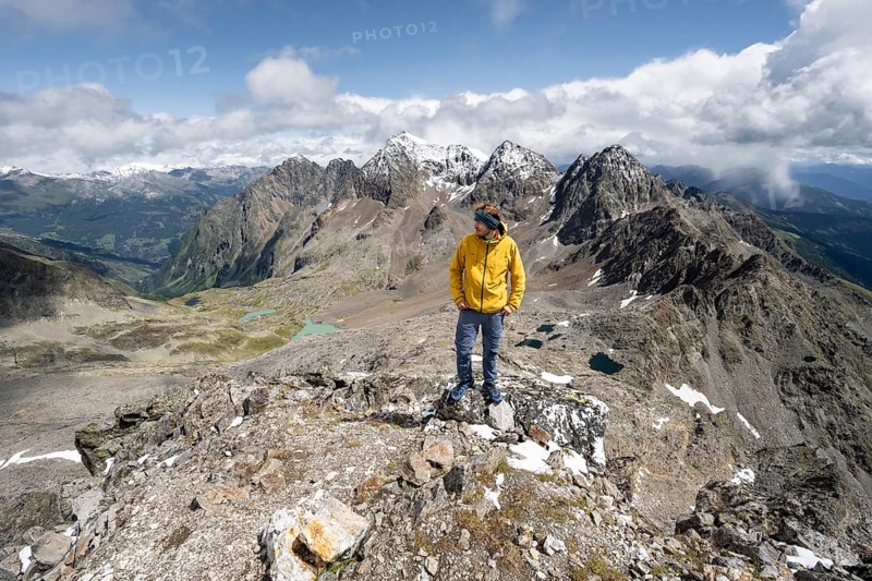 Mountaineer in rocky mountain landscape, at the summit of Keeskopf, behind summit of Petzeck, Hoher Perschitzkopf and Kruckelkopf, Schober group, Hohe Tauern National Park, Carinthia, Austria, Europe