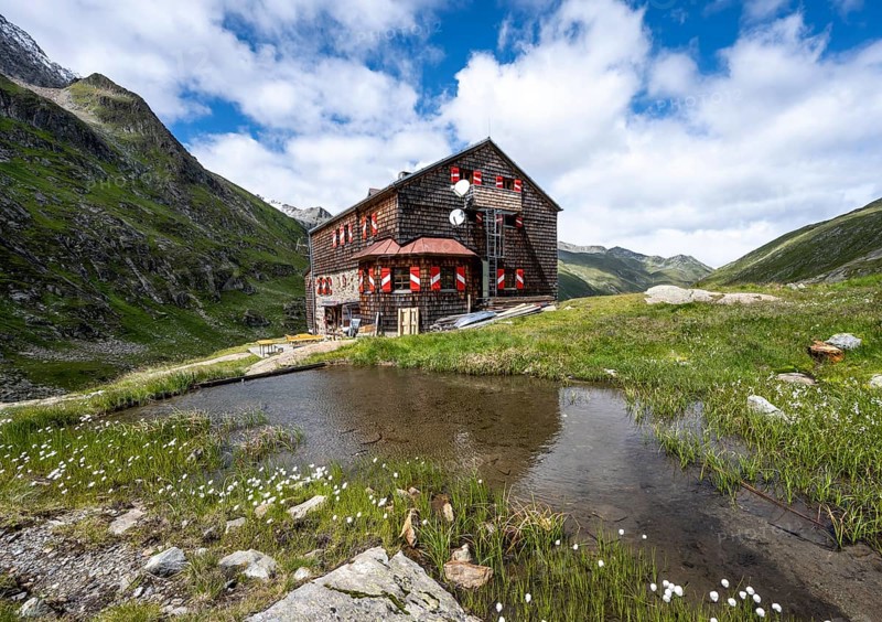 Elberfelderhütte mountain hut with small lake and cotton grass, in the upper Gössnitz valley, Vienna High Trail, Schober Group, Hohe Tauern National Park, Carinthia, Austria, Europe
