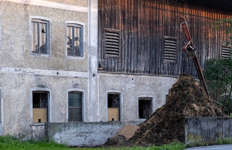 Farmhouse with dung heap next to a rustic wooden wall, Bavaria, Germany, Europe