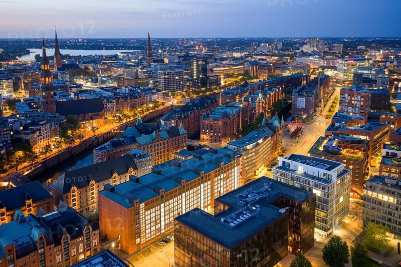 Aerial view of the Speicherstadt Hamburg at blue hour with churches and Alster in the background, Hamburg, Germany, Europe