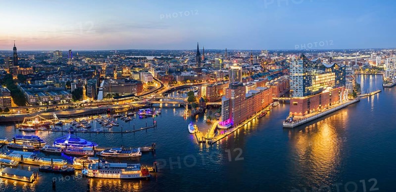 Panorama aerial view of the Elbphilharmonie at blue hour with illuminated windows and view over Landungsbrücken, Speicherstadt and Hafencity, Hamburg, Germany, Europe