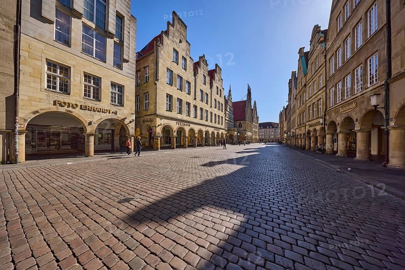 Old town, historic buildings, facade, window, gable, arcades, cobblestone street, pedestrians as secondary motif, sidelight, backlight, blue cloudless sky, Prinzipalmarkt, Münster, Münsterland, independent city, North Rhine-Westphalia, Germany, Europe