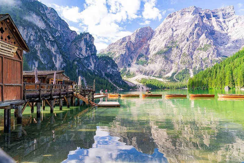 Wooden huts on the lakeshore against a majestic mountain backdrop and calm waters, Lake Braies, South Tyrol, Dolomites, Italy, Europe