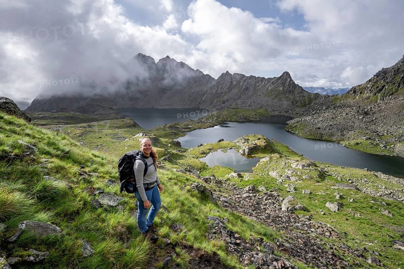 Mountaineer on hiking trail, view of mountain landscape with mountain lakes Wangenitzsee and Kreuzsee, cloudy mountain peaks in the morning light, Schober Group, Hohe Tauern National Park, Carinthia, Austria, Europe