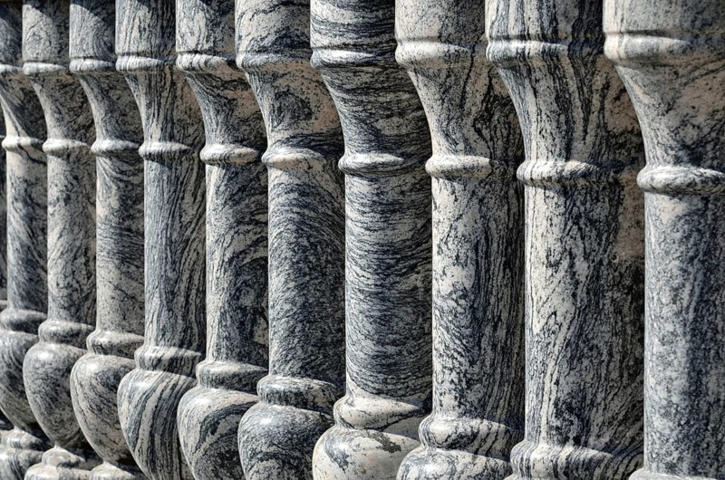 Beautiful gray marble balustrade illuminated by the bright sun. Stone background