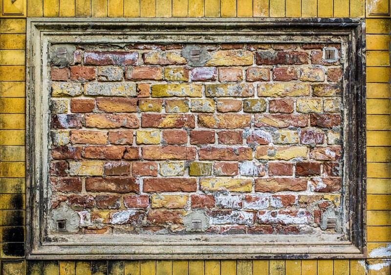 Old brick wall pattern closeup with stucco frame