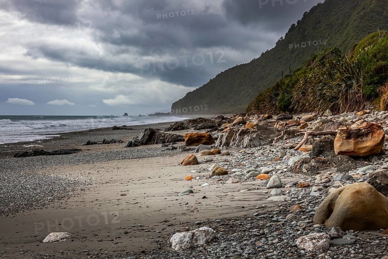 Stormy weather approaching a rock strewn beach in New Zealand