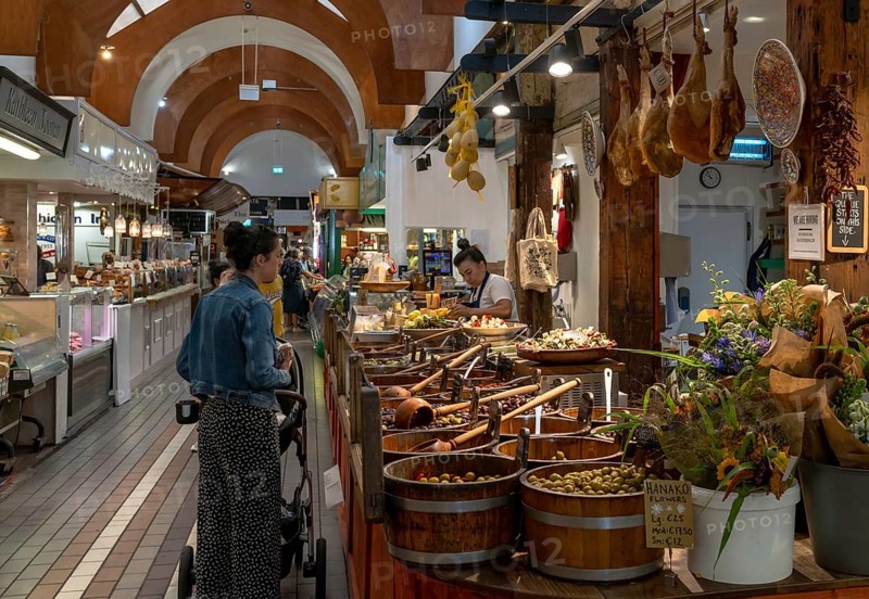 Cork, Ireland, 16 August, 2022: customers buying food at a market stall with Spanish delicacies and Iberico Hams, Europe