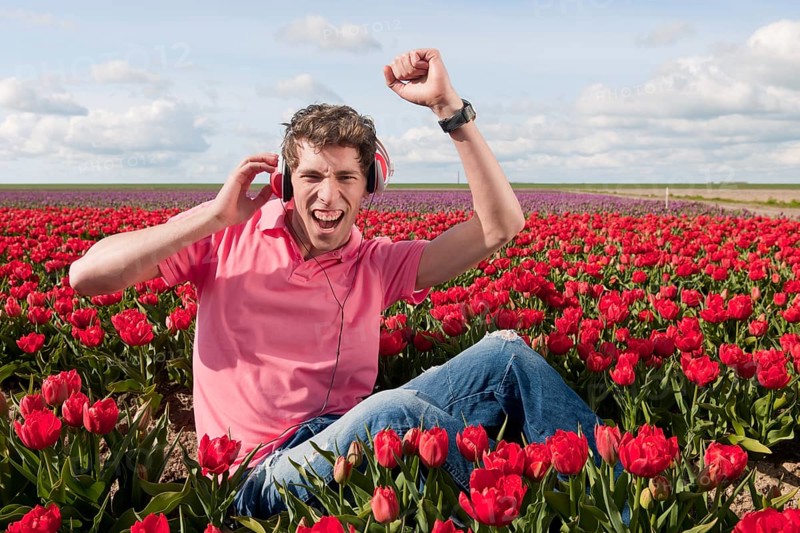Dutch man sitting in flower fields listeing to cool music