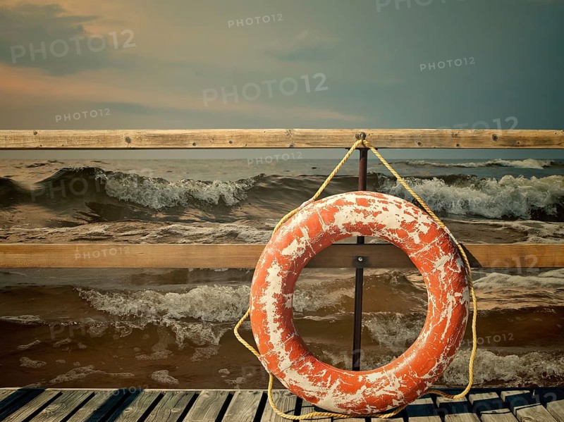 Storm at the sea, pier with life buoy