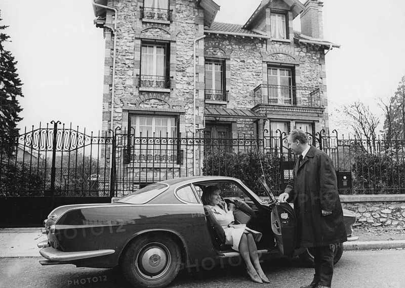 Volvo P1800. A sports car manufactured by Volvo Cars wtih start 1961 and ending 1973. Styling was by swedish designer Pelle Pettersson. The car was indroduced at the Geneva Motor Show in 1961. The P1800 became widely known when driven by then future James Bond actor Roger Moore as Simon Templar in the television series The Saint. Pictured here swedish actress Gunnel Lindblom with her husband outside their villa in France with their Volvo P1800. 1965