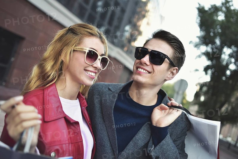 Portrait of a couple with shopping bags in the city.People, sale, love and happiness concept