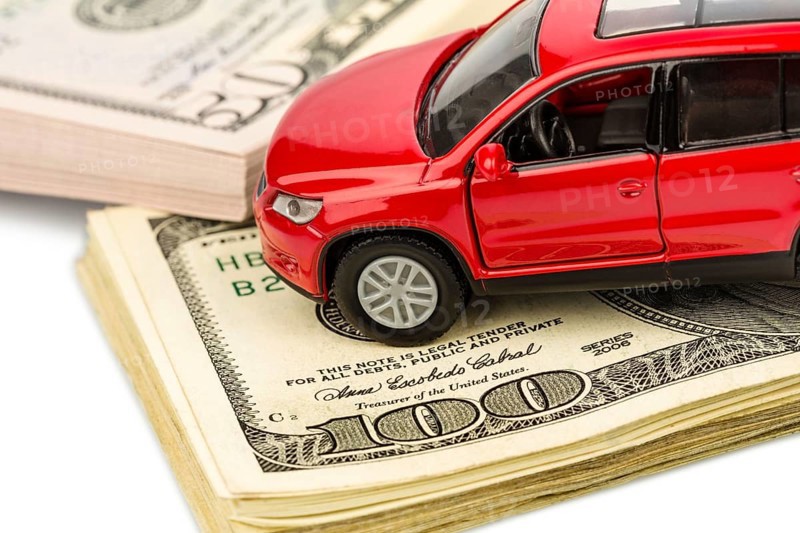 A car is written on dollar notes. Costs for car purchase, petrol, insurance and other car costs Austria