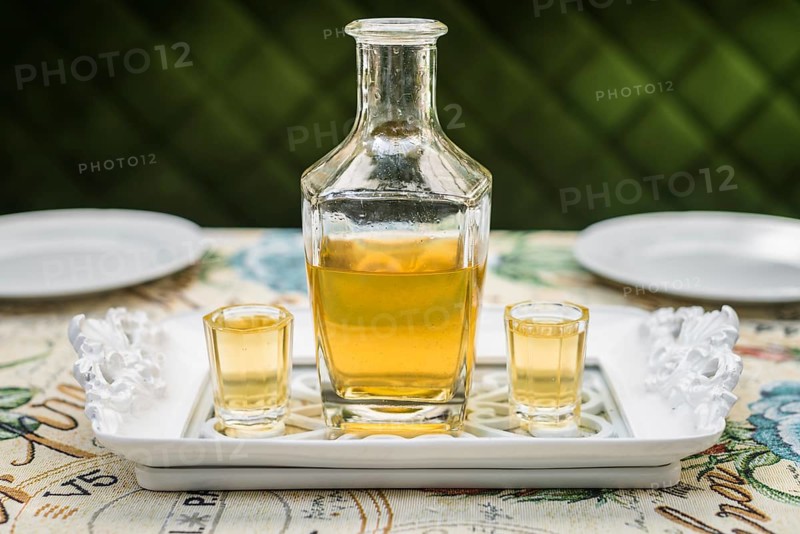 Carafe with honey vodka on white elegant tray