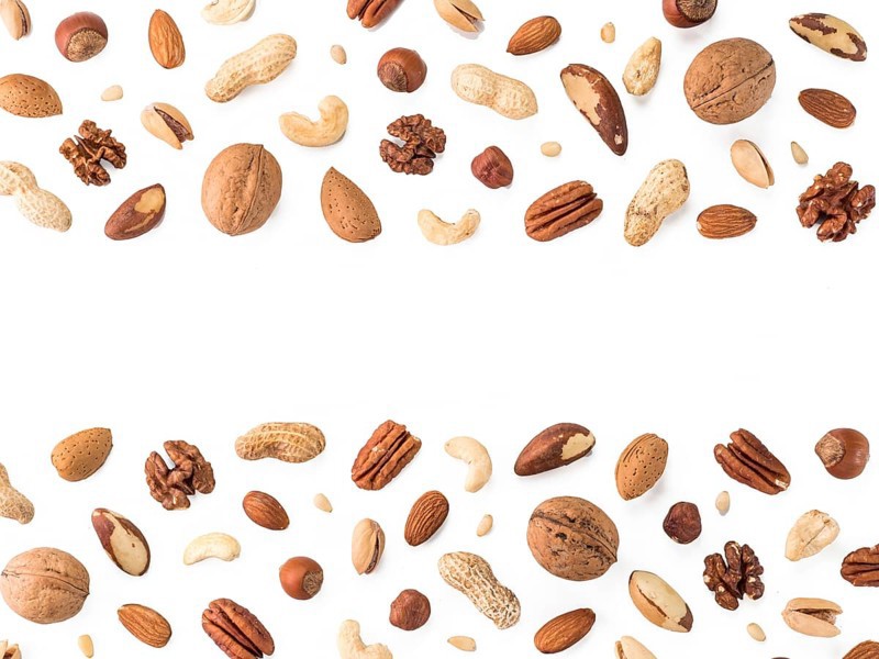 Pattern of nuts mix with copy space. Various nuts isolated on white. Pecan, macadamia, brazil nut, walnut, almonds, hazelnuts, pistachios, cashews, peanuts, pine nuts. Top view or flat-lay. Copy space