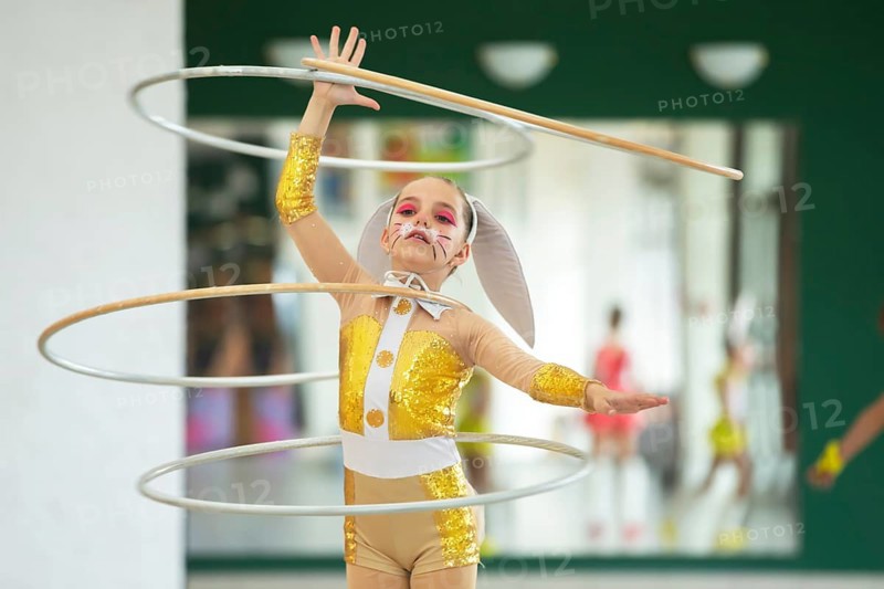 A little girl doing gymnastics in a bunny costume turns gyms