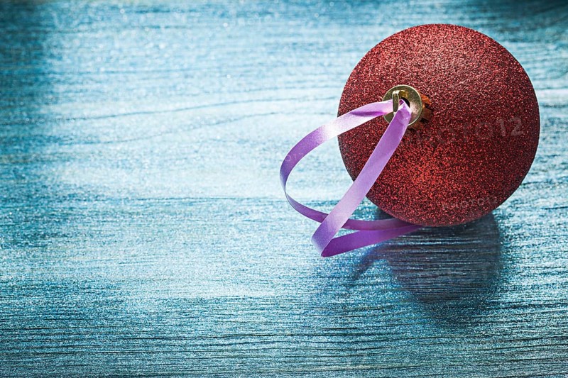 Red shining Christmas ball on wooden board holidays concept