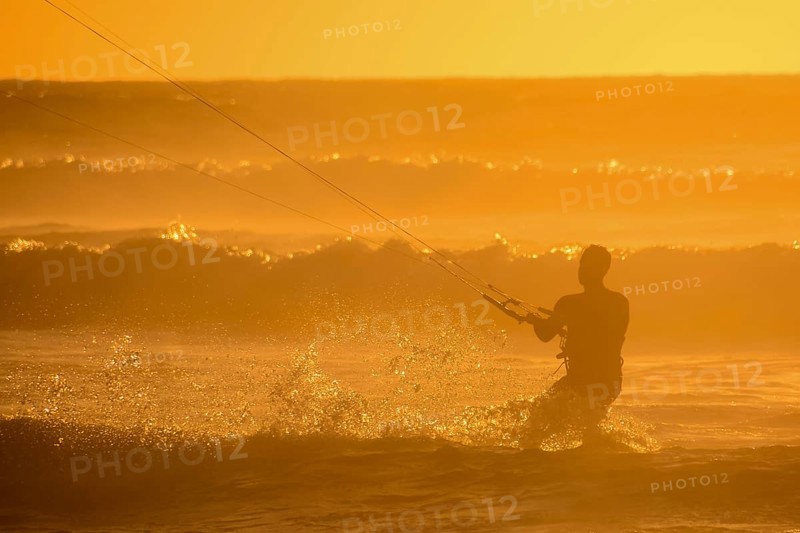 Single surfer at sunset on a calm ocean