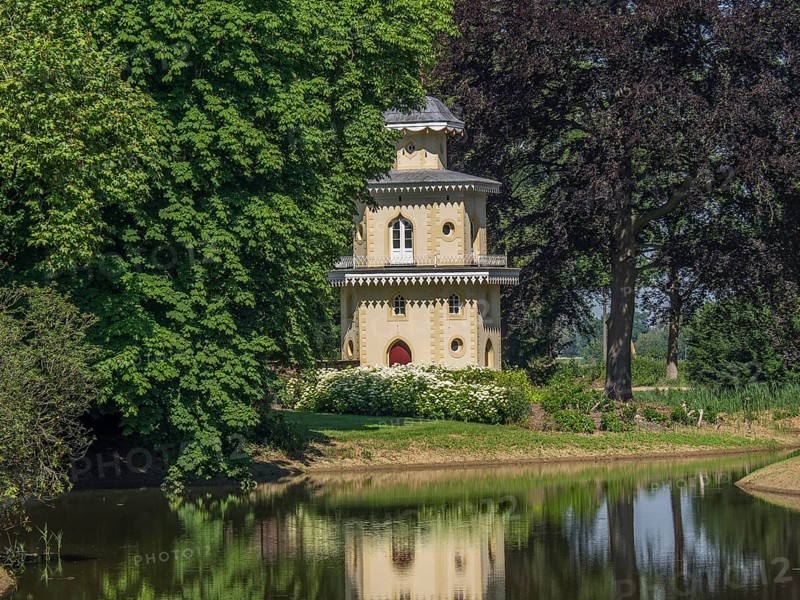 Historic turret flanked by trees, reflected in the neighbouring water, ulft, gelderland, netherlands
