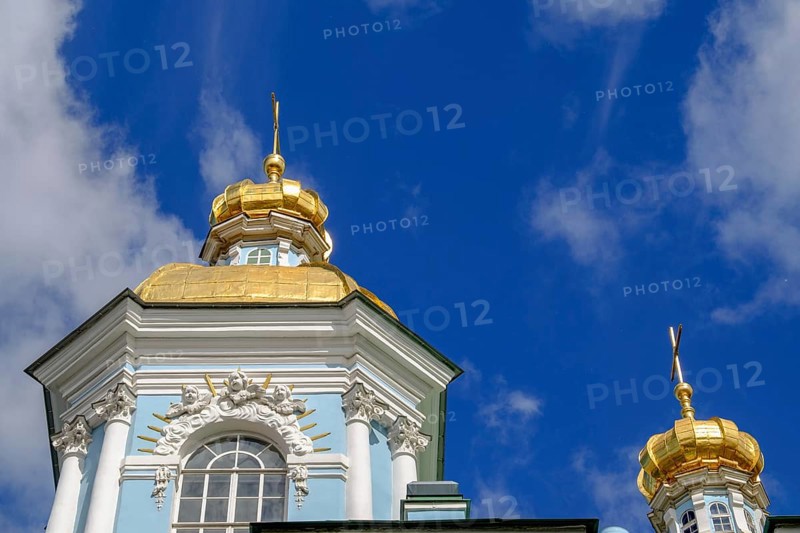 Baroque building with a blue façade and magnificent golden domes against a deep blue sky in St. Petersburg