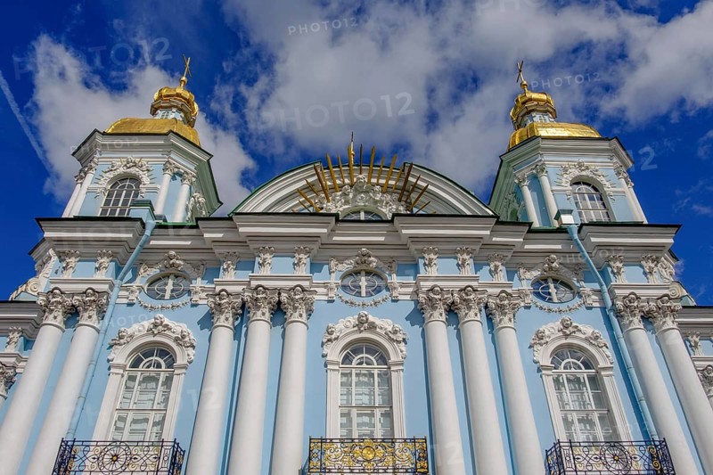 A magnificent church with golden domes, a blue façade and white columns