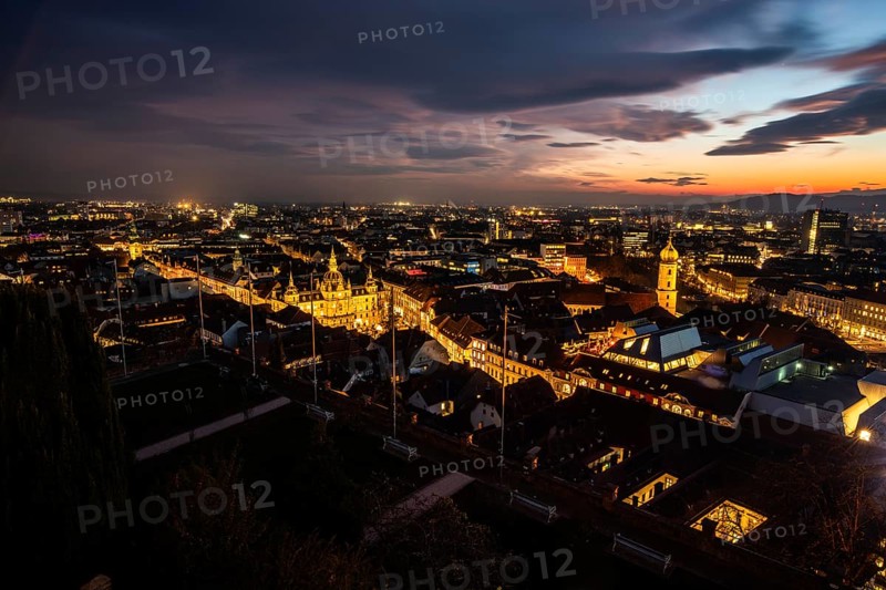 Sunset over the old town of Graz, view from the Schlossberg, illuminated tower of the Franciscan church, illuminated town hall, roofs in the old town, blue hour, Graz, Styria, Austria, Europe