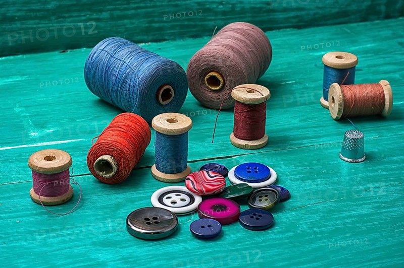 Thread buttons for crafts on turquoise wooden background.selective focus