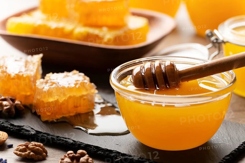 Honeycomb on slate tray with honey and nuts on kitchen table, food photography, food photography