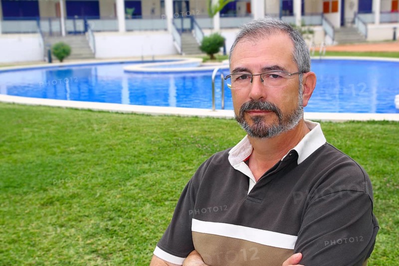 Senior retired man glasses relax on vacation garden pool